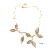 a necklace with marble filled leaves with a gold chain on a white background. "Side B"