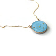 White background with Gold filled Double Sided Custom Constellation Necklace with the cancer constellation shown on the sky blue side. Custom stamping across the bezel says "nineteen"